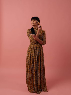 Karışık ırk kadın makyaj gül pembe bir arka plan üzerinde fırça ile uygulanması