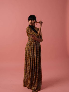 Karışık ırk kadın makyaj gül pembe bir arka plan üzerinde fırça ile uygulanması