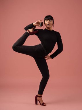 Aptal komik poz, pembe arka plan izole telefonda konuşurken bir İspanyol kadın portresi