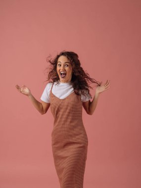 Pembe bir arka plan üzerinde rahat kıyafet mutlu beyaz kadın. Yaratıcı otantik atış