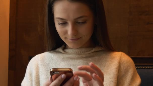 Mujer bonita usando la aplicación en el teléfono inteligente en la cafetería beber café — Vídeo de stock