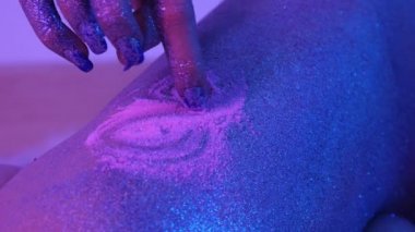 Güzel kadın bacağında ultraviyole ışık parıldıyor ile boyama