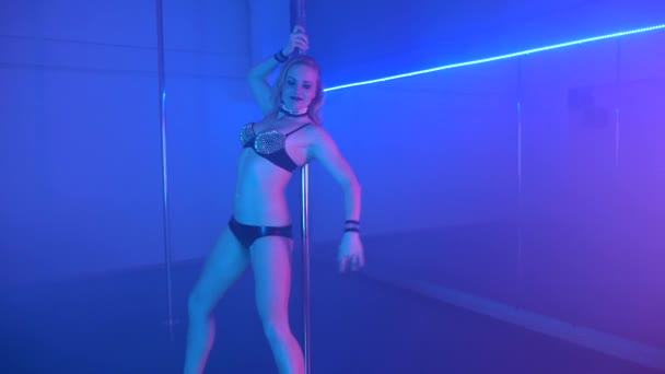 Ung sexig smal kvinna pole dance med pylon i mörk interiör — Stockvideo