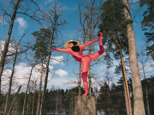 Woman at forest practicing yoga fitness exercise and meditating in traditional hat. 4k slow motion