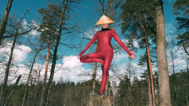 Mujer en el bosque practicando yoga ejercicio físico en sombrero tradicional — Vídeos de Stock