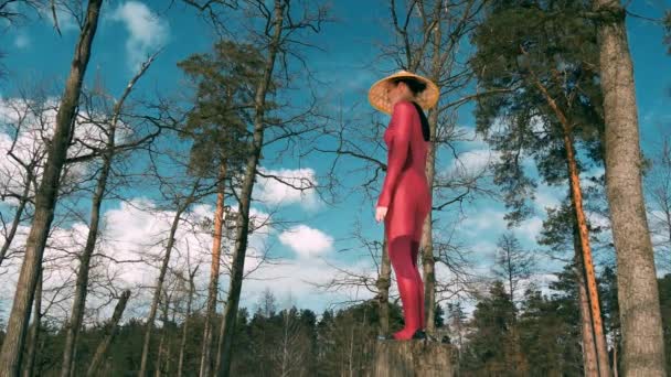 Frau im Wald praktiziert Yoga-Fitnessgymnastik mit traditionellem Hut — Stockvideo