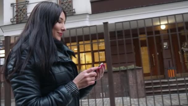 都市の街を歩いてスマート フォン技術アプリケーションを使用して美しい混血女性幸せ — ストック動画