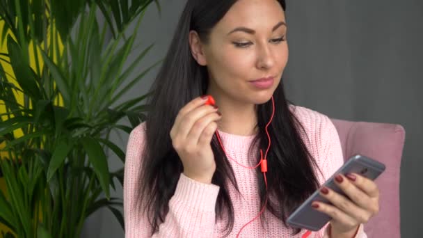 Mujer hipster de raza mixta en auriculares escuchando música desde el teléfono inteligente en la cafetería — Vídeo de stock