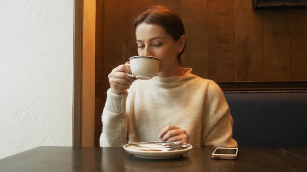 Businesswoman with smartphone drinking coffee in cafe — Stock Video