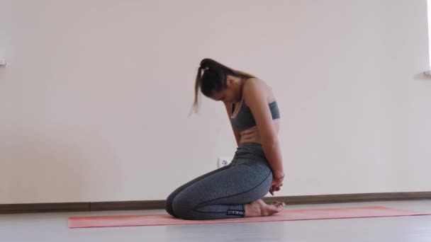 Fitness vrouw doen uitrekkende training op oefening mat. Jonge vrouw uit te oefenen op fitness mat binnen — Stockvideo