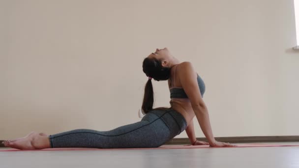 Fitness female doing stretching workout on exercise mat. Young woman exercising on fitness mat indoor — Stock Video