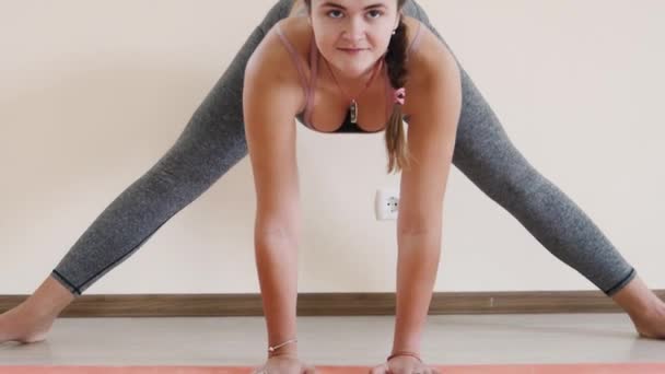 Fitness žena dělá protahovací cvičení na cvičení mat. Mladá žena cvičení na fitness mat krytý — Stock video