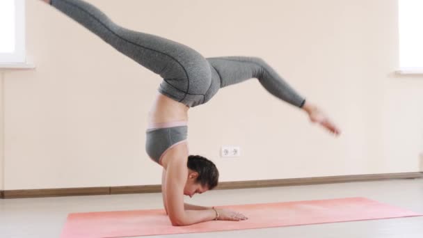 Фитнес-женщина делает растяжку тренировки на коврик для упражнений. Молодая женщина, занимающаяся спортом в помещении — стоковое видео