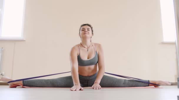 Fitness femminile facendo allenamento di stretching sul tappeto esercizio. Giovane donna che esercita sul tappeto fitness indoor — Video Stock