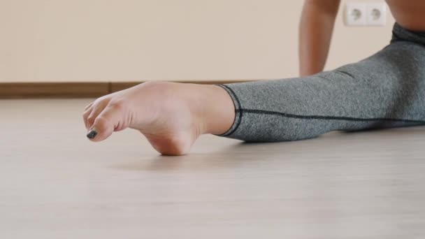 Fitness feminino fazendo alongamento treino no tapete de exercício. Jovem mulher se exercitando no tapete de fitness indoor — Vídeo de Stock