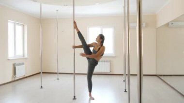 Fitness erkek germe egzersiz akrobasi ayna yakınındaki yapıyor. Genç kadın fitness mindere kapalı egzersiz