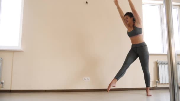 Fitness kvinna gör stretching träning akrobatik. Ung kvinna tränar inomhus — Stockvideo