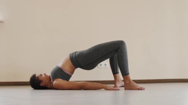 Fitness femelle faire de l'exercice d'étirement sur tapis d'exercice. Jeune femme exerçant sur tapis de fitness intérieur — Video