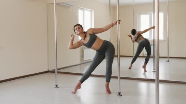 Ung sexig kvinna utbildning poledance fitness motion flicka stretching inomhus. — Stockvideo