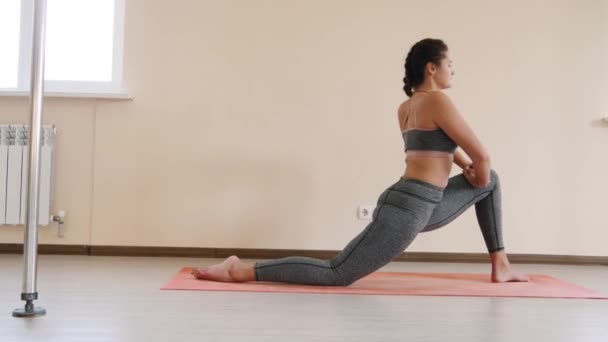 Fitness kvinna stretching träning på träningsmatta. Ung kvinna utövar på fitness mat inomhus — Stockvideo