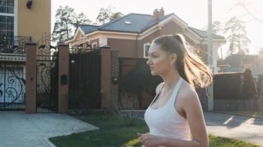 Atletik açık havada park beton yolda ağır çekimde çalışan kadın. Sağlıklı fitness kavramı