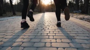 Açık havada park beton yolda ağır çekimde çalıştıran atletik kadın bacak kapatın. Sağlıklı fitness kavramı