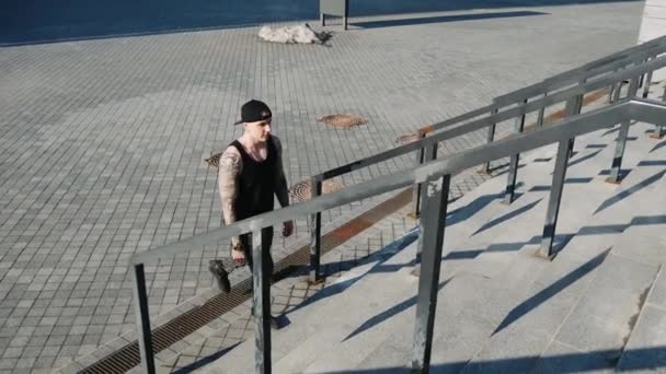 Contemporâneo hip hop dançarino de rua hipster homem com tatuagem sobe as escadas — Vídeo de Stock