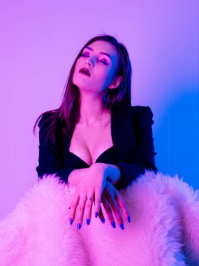 Seksi güzel kadın giyim ceket kürk ultraviyole ışık sandalyede oturan