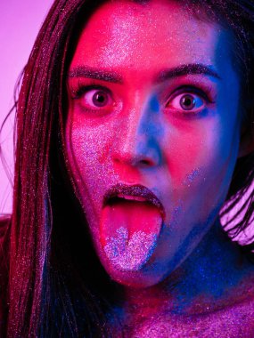 Sparkles ultraviyole ışık aptal yüz diliyle gösterilen yüzünde güzel bir kadınla.