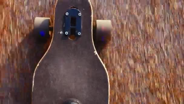 Top view handheld shot of man in blue sneakers or skaters shoes rides longboard on asphalt or city — Stock Video