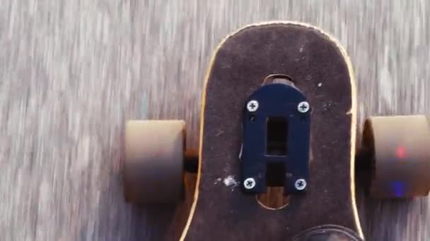 Top view handheld shot of man in blue sneakers or skaters shoes rides longboard on asphalt or city — Stock Video