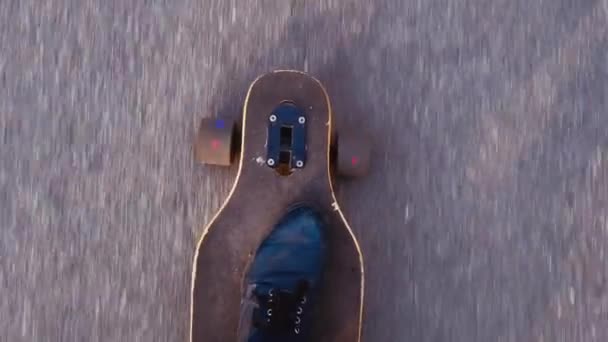 Vista superior de la toma de mano del hombre en zapatillas de deporte azules o patinadores zapatos paseos longboard en asfalto o ciudad — Vídeos de Stock