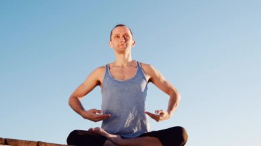 Genç Beyaz adam tarafından pratik yoga fitness egzersiz city adlı arka plan ile sakin Nehri yakınında sahilde rahatlatıcı