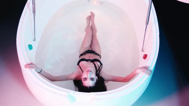 Mujer joven flotando en bañera de hidromasaje o piscina, está muy relajada. Concepto de solidez — Vídeos de Stock