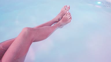 Genç yakın kadın bacaklar, Spa banyo veya yüzme havuzunda yüzen çok rahat olduğunu. Başak kavramı