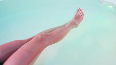 Genç yakın kadın bacaklar, Spa banyo veya yüzme havuzunda yüzen çok rahat olduğunu. Başak kavramı