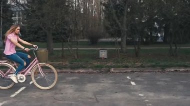 Kızıl saçlıya zencefil kız yaz Şehir Parkı sokakta sepet bir bisiklet sürme