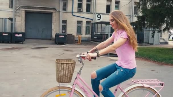 Pretty redhead ginger girl riding a bike with basket on the street in summer city park — Stock Video