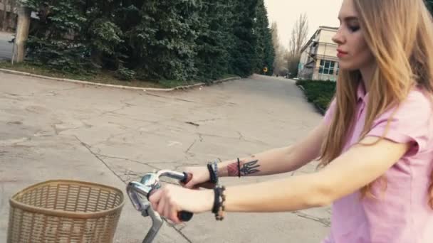 Vackra redhead ingefära flicka rider en cykel med korg på gatan i sommar stadspark — Stockvideo