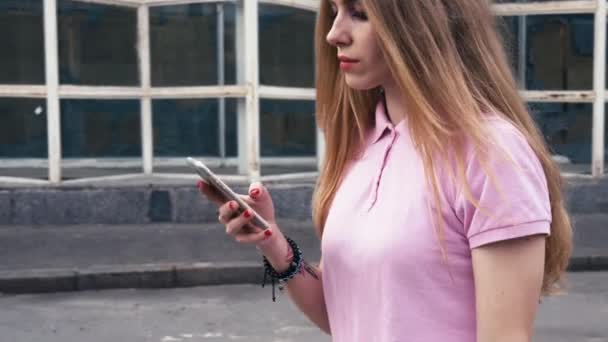 Pelirroja pelirroja usando teléfono móvil durante un paseo por las calles de la ciudad — Vídeo de stock