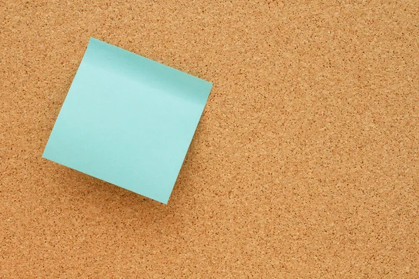 Tablón de anuncios con una nota adhesiva en blanco de color verde azulado —  Fotos de Stock