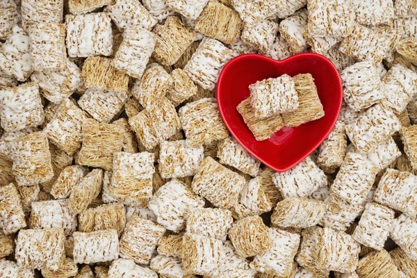 Fundo de cereais de grão inteiro saudável com uma tigela de coração — Fotografia de Stock