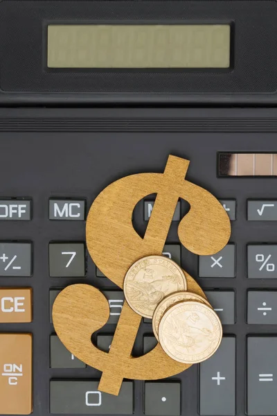 Крупный план калькулятора со знаком доллара и золотыми монетами — стоковое фото