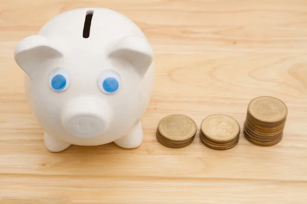 A piggy bank on a desk with gold coins — Stock Photo, Image