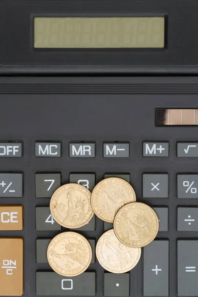 Крупный план калькулятора с золотыми монетами — стоковое фото