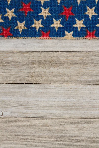風化した木材の背景に赤と青の星黄麻布リボン — ストック写真