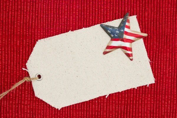 Uma etiqueta de presente de pano com uma estrela de bandeira americana retro em ma vermelho brilhante — Fotografia de Stock