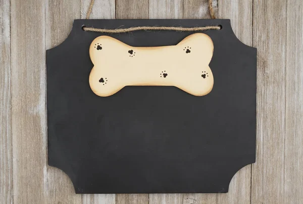 Závěsné tabule s dřevěné psí kost na zvětralé dřevo zeď — Stock fotografie
