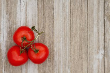 Yıpranmış ahşap arka plan üzerinde kırmızı asma olgun domates