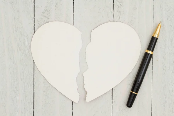 Tarjeta en blanco en forma de corazón con un bolígrafo sobre fondo de madera envejecida — Foto de Stock